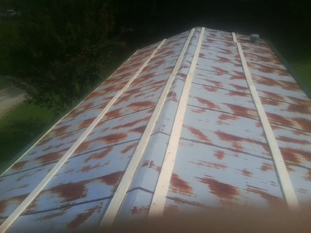 Rusted metal roof panels with new wood purlins before replacement — Storm Damage Roof Repair in Nesbit by Roofing Brothers